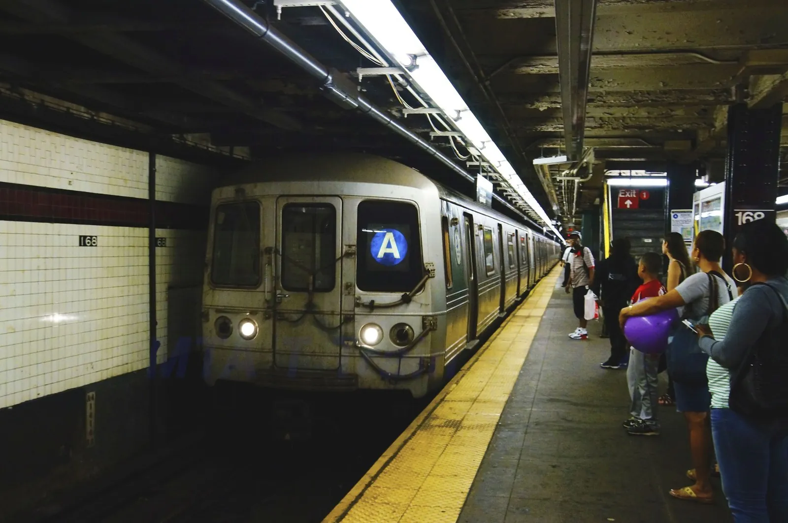 MTA NYC Subway train arriving at station platform in Manhattan.
