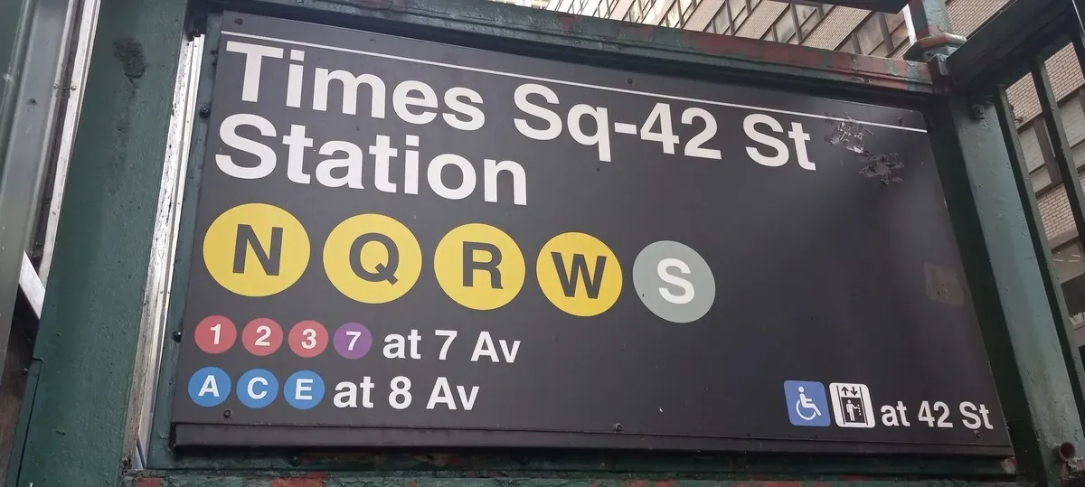 Manhattan subway station entrance with green globe lamp and MTA signage